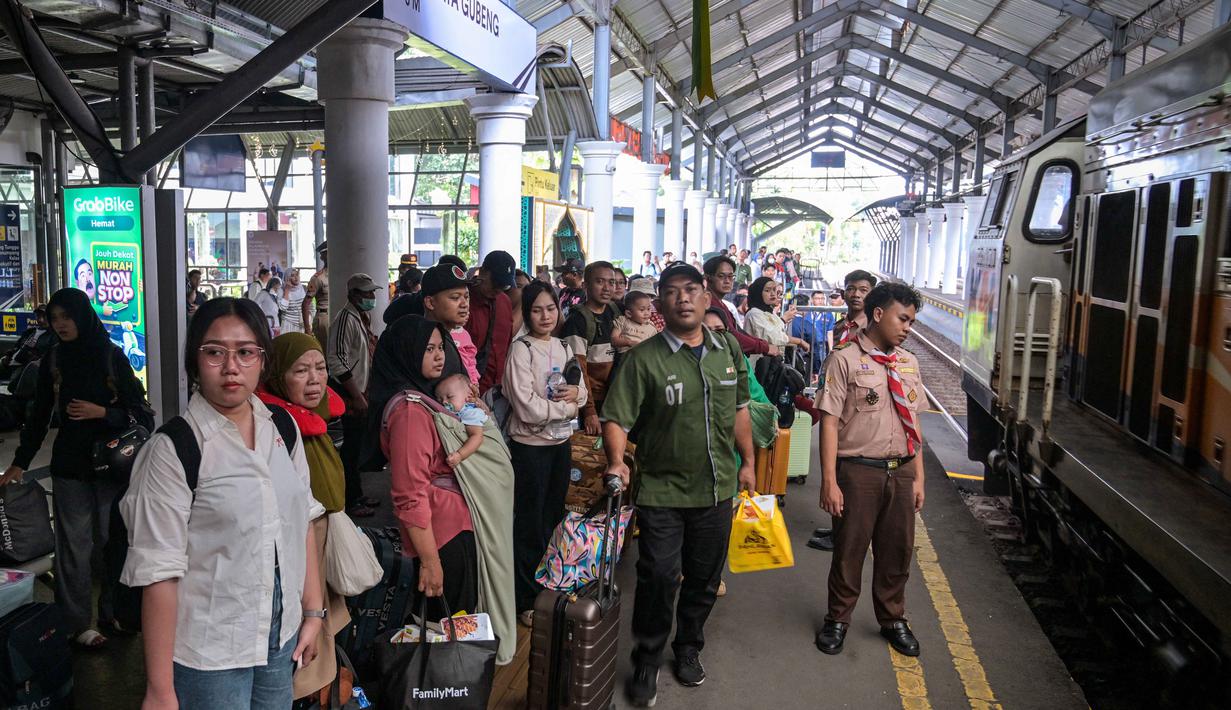 Jumlah tersebut terdiri dari 26.555 penumpang keberangkatan dan 20.670 kedatangan. Tampak dalam foto, para penumpang menunggu untuk naik kereta di stasiun Gubeng, Surabaya, Jawa Timur, Selasa 17 Maret 2026. (JUNI KRISWANTO/AFP)