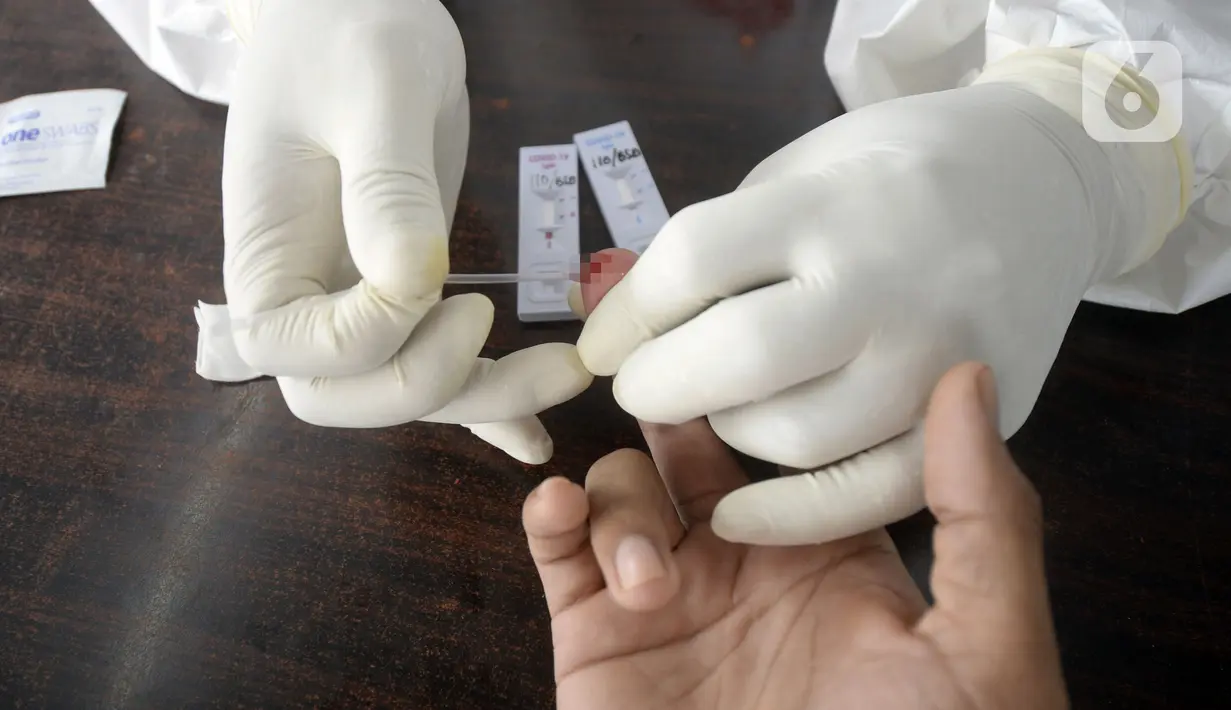 Petugas medis mengambil sampel darah saat screening test virus corona COVID-19 di Pasar Modern BSD, Tangerang Selatan, Banten, Selasa (21/4/2020). Screening test pendeteksi dini tersebut dilakukan di 12 lokasi di Tangerang Selatan untuk menanggulangi COVID-19. (merdeka.com/Dwi Narwoko)