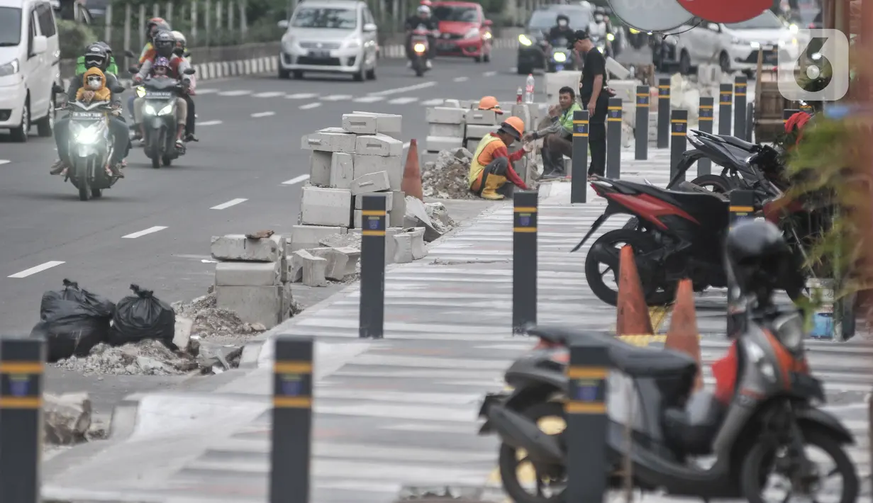 Aktivitas pekerja saat menyelesaikan proyek revitalisasi trotoar di Jalan Margonda Raya, Depok, Jawa Barat, Minggu (4/12/2022). Penataan trotoar di Jalan Raya Margonda, Depok, mengusung konsep instagramable. Konsep tersebut sebagai upaya meningkatkan minat masyarakat untuk berjalan kaki.(merdeka.com/Iqbal S Nugroho)