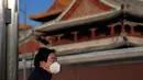 Seorang warga yang mengenakan masker berdiri dekat Kuil Lama di Beijing, China, 27 Desember 2022. Perusahaan menyambut baik keputusan China untuk mengakhiri karantina bagi pelancong dari luar negeri sebagai langkah penting untuk menghidupkan kembali aktivitas bisnis yang merosot, sementara Jepang mengumumkan pembatasan pengunjung saat infeksi melonjak. (AP Photo/Ng Han Guan)