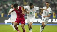 Bek Timnas Indonesia Asnawi Mangkualam&nbsp;berebut bola dengan pemain&nbsp;Irak Merchas Doski pada pertandingan Kualifikasi Piala Dunia 2026 zona Asia di&nbsp;Basra Sport City Stadium, Kamis, 16 November 2023. (Hussein Faleh / AFP)