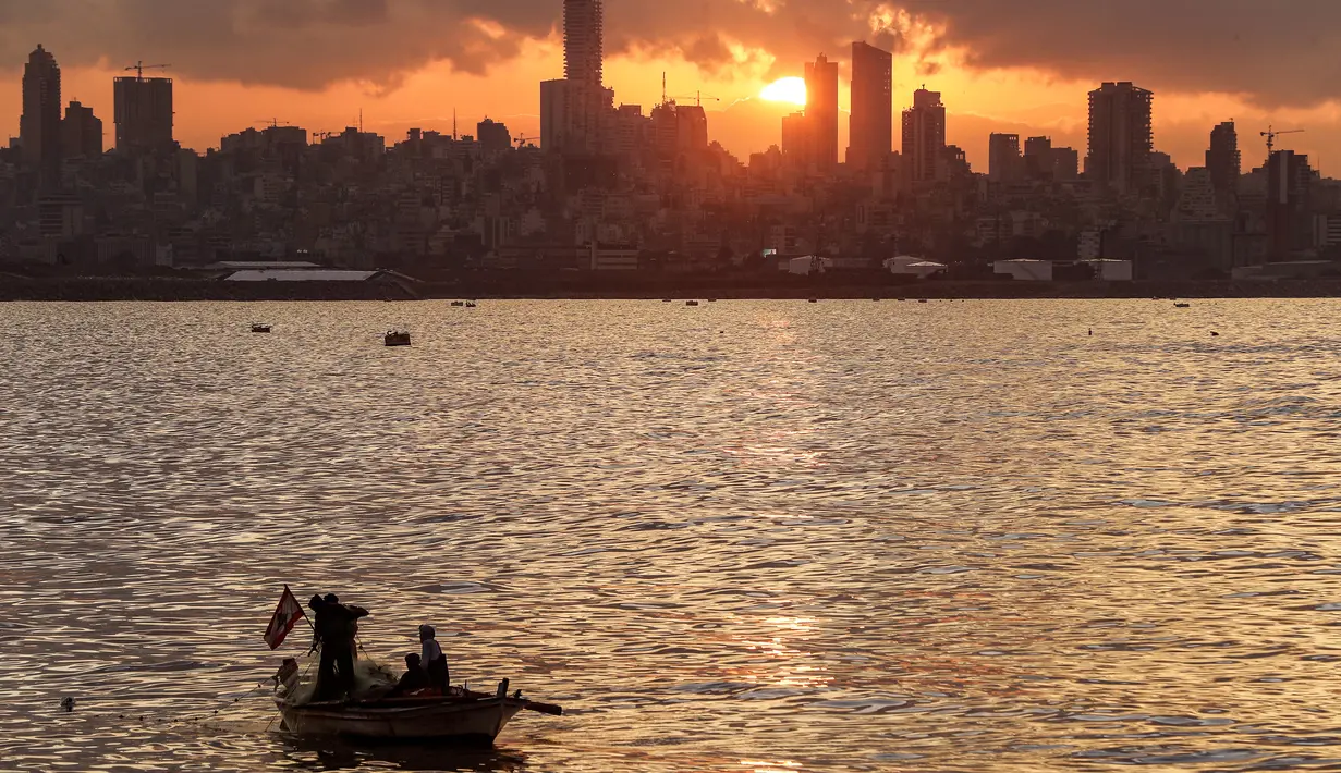 Nelayan melemparkan jala dari perahu saat matahari terbenam ke laut Mediterania di daerah Dbayeh, utara ibukota Beirut (5/12/2019). Laut Tengah, kadangkala disebut Laut Mediterania adalah laut antarbenua yang terletak antara Eropa di utara, Afrika di selatan dan Asia di timur. (AFP/Josep Eid)