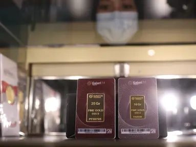 Karyawan menunjukkan kepingan emas yang dijual di Galeri 24, Jakarta, Selasa (15/12/2020). Harga emas hasil produksi PT Aneka Tambang Tbk (Antam) atau emas Antam kini turun Rp 1.000 per gram menjadi Rp 951 per gram pada perdagangan, Selasa (15/12). (Liputan6.com/Angga Yuniar)