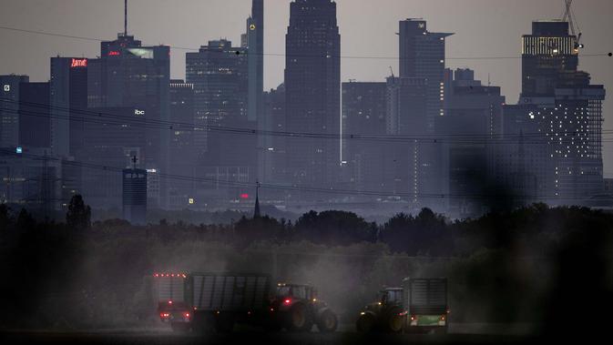 Traktor berkendara di lahan seluas satu hektar dengan gedung-gedung kawasan perbankan di Frankfurt, Jerman, Kamis (17/9/2020). (AP Photo / Michael Probst)
