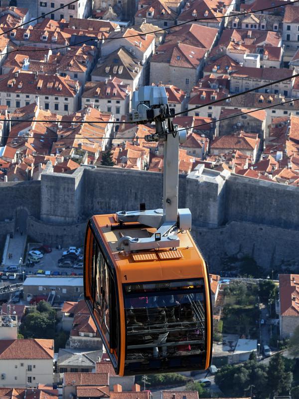 Turis menaiki kereta gantung melewati puncak bukit Srd di atas kota tua Dubrovnik pada 28 Maret 2019. Tahun lalu lebih dari 1,2 juta turis mengunjungi Dubrovnik, kota yang paling banyak dikunjungi di Kroasia. (Denis LOVROVIC / AFP)