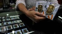 Pedagang menunjukan emas batangan 50 gram dan 100 gram di sebuah toko Kawasan Cikini, Jakarta, Kamis (3/9/2015). Harga emas milik PT Aneka Tambang Tbk (Antam) hari ini terpantau bergerak stabil di posisi Rp560 ribu per gram. (Liputan6.com/Johan Tallo)
