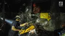 Petugas memotong minibus yang ringsek puing usai  kecelakaan kereta api di perlintasan Kramat, Senen, Jakarta, Selasa (13/6). Petugas menemukan dua orang yang tewas terbakar. (Liputan6.com/Helmi Afandi)