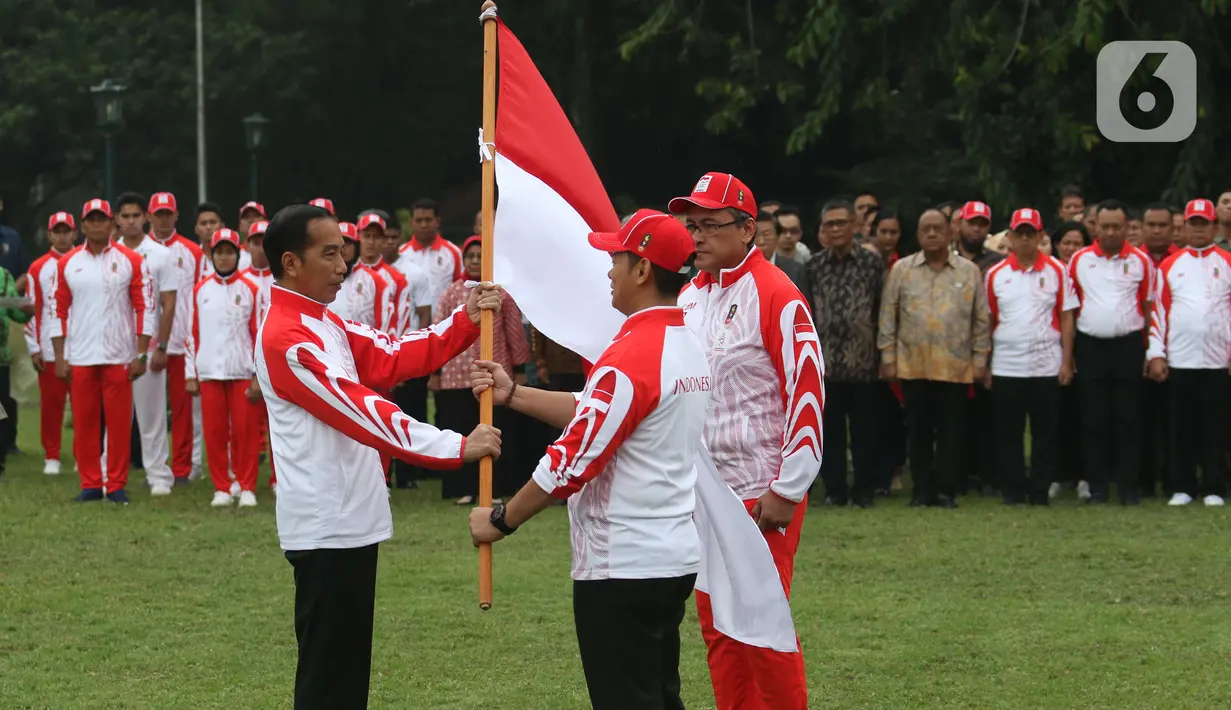 Presiden Joko Widodo atau Jokowi menyerahkan Bendera Merah Putih kepada Ketua National Olympic Committe (NOC) Raja Sapta Oktohari saat acara pelepasan Kontingen Indonesia untuk SEA Games 2019 Filipina di Istana Bogor, Rabu (27/11/2019). (Liputan6.com/Angga Yuniar)