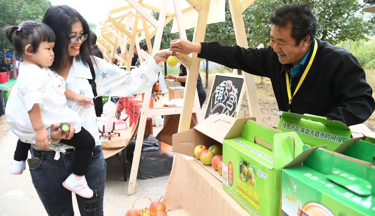 Warga melihat produk-produk pertanian yang dipamerkan pada pembukaan acara perayaan untuk menandai festival panen petani China di Distrik Pinggu, Beijing, ibu kota China, pada 24 September 2020. (Xinhua/Ren Chao)