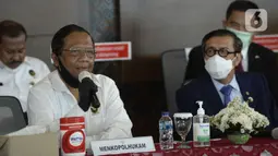 Menko Polhukam Mahfud MD (kiri) dan Menkumham Yasonna H Laoly menyampaikan keterangan terkait pemulangan buron Maria Pauline Lumowa di Bandara Soekarno-Hatta, Tangerang, Banten, Kamis (9/7/2020). Maria merupakan pembobol kas BNI Cabang Kebayoran Baru senilai Rp 1,2 triliun. (merdeka.com/Dwi Narwoko)