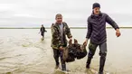 Sejumlah orang membawa pecahan tulang mammoth di Danau Pechevalavato, Yamalo-Nenets, Rusia, Rabu (22/7/2020). Fragmen kerangka mammoth tersebut ditemukan oleh para penggembala rusa lokal. (Artem Cheremisov/Governor of Yamalo-Nenets region of Russia Press Office via AP)