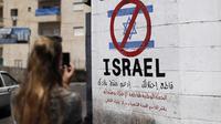 Sebuah tanda di dinding di kota Bethlehem, West Bank, menyerukan pemboikotan produk Israel dari permukiman Yahudi, pada 5 Juni 2015. (Thomas Coex/AFP)