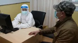 Seorang dokter berkomunikasi dengan pasien COVID-19 yang dinyatakan sembuh tentang skema rehabilitasinya di Rumah Sakit TCM Provinsi Hubei di Wuhan, Provinsi Hubei, China tengah (21/4/2020). Pekerja medis di klinik ini merawat pasien berdasarkan teori TCM. (Xinhua/Wang Yuguo)