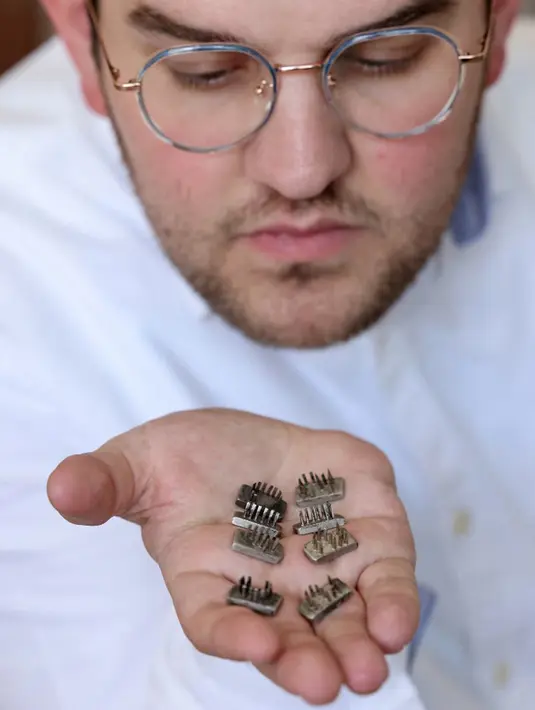Stempel tato yang digunakan Nazi pada Yahudi dan narapidana Auschwitz lainnya dipajang oleh pemilik rumah lelang Tzolman, Meir Tzolman, di Yerusalem, 8 November 2021. Pengadilan Israel mengeluarkan perintah untuk menghentikan lelang stempel tato tersebut. (EMMANUEL DUNAND/AFP)