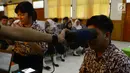 Petugas membantu siswa merekam identitas menggunakan pemindai mata saat pembuatan E-KTP di SMKN 28, Jakarta, Kamis (10/1). (Merdeka.com/Imam Buhori)