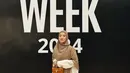 Natasha Rizky mengenakan dress loose putih dipadukan kerudung coklat tua serta rok denim dan flat shoes. Sambil membawa mini bag coklat. [@natasharizkynew]