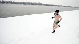Seorang pelari ambil bagian dalam Underpants Run di tepi sungai Danube, Serbia pada 26 Januari 2019. Peserta berlari hanya dengan mengenakan pakaian dalam di tengah suhu yang mendekati 0 derajat Celcius. (AP/Darko Vojinovic)