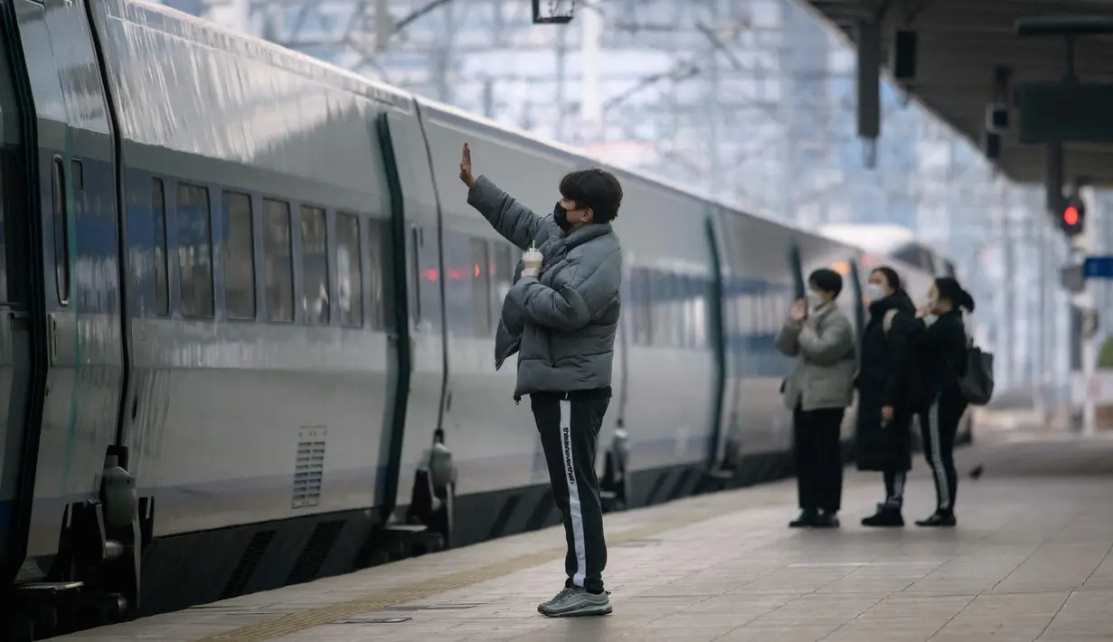Seorang pria mengucapkan selamat tinggal dari peron stasiun kereta api Seoul, menjelang liburan Tahun Baru Imlek pada Rabu (10/2/2021). Sebelumnya pada 31 Januari 2021, otoritas memperpanjang dua pekan kewajiban jaga jarak untuk jaga-jaga menyusul libur tahun baru China atau imlek. (Ed JONES/AFP)