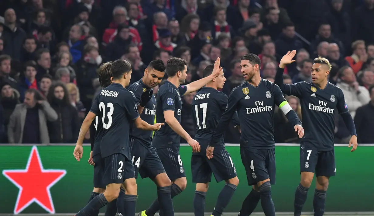 Perayaan gol Real Madrid yang dicetak Karim Benzema pada leg 1, 16 besar Liga Champions yang berlangsung di stadion Amsterdam Arena, Amsterdam, Kamis (14/2). Real Madrid menang 2-1 atas Ajax. (AFP/Emmanuel Dunand)