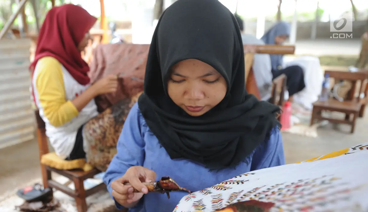 Perajin membuat batik tulis khas Betawi di rumah produksi Keluarga Batik Betawi, Setu Babakan, Jakarta Selatan, Minggu (10/3). Kain batik Betawi ini dijual seharga Rp 135  ribu hingga Rp 800 ribu per helai. (merdeka.com/Arie Basuki)