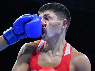 Petinju Kazakhstan, Berik Abdrakhmanov, terkena pukulan lawannya petinju AS, Carlos Zenon Balderas Jr, dalam laga kelas ringan (60 kg) Olimpiade Rio 2016 di Pavilion 6 Riocentro, Rio de Janeiro, Brasil, (6/8/2016). (AFP/Yuri Cortez)