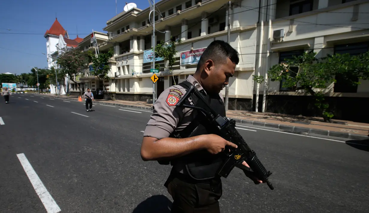 Aparat kepolisian menutup jalan setelah serangan bom bunuh diri di Polrestabes Surabaya, Jawa Timur, Senin (14/5). Ada anggota polisi yang menjadi korban serangan ini, tetapi belum diketahui apakah meninggal ataupun terluka. (AP/Achmad Ibrahim)