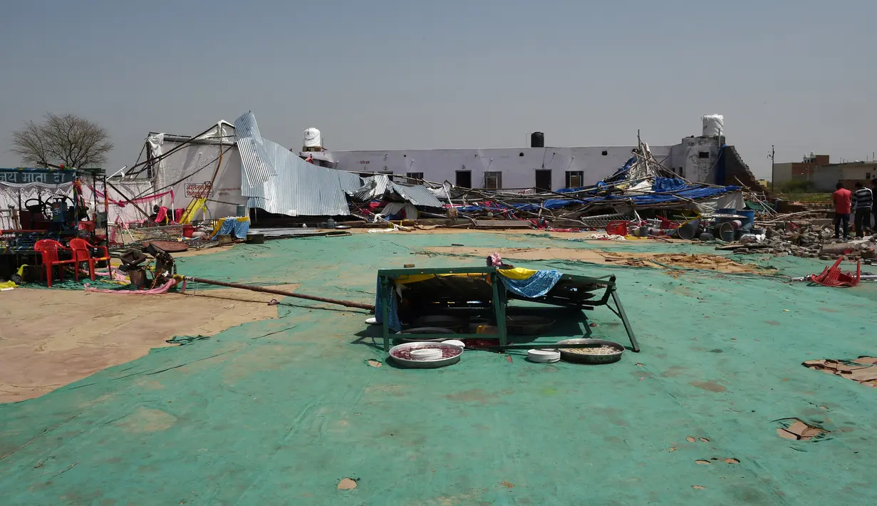Puing-puing berserakan di lokasi ambruknya sebuah tembok bangunan yang dijadikan pesta pernikahan di Rajashtan, India, Kamis (11/5). Polisi menyebut tembok yang roboh tersebut memiliki panjang 27 meter dan tinggi 3 meter. (MONEY SHARMA/AFP)
