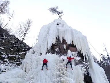 Orang-orang memanjat dinding es buatan di desa Vir, Republik Ceko, Minggu (14/2/2021). Ketika suhu turun di Republik Ceko, pemanjat tebing memanfaatkan kondisi beku dengan mengubah permukaan batu menjadi dinding es setinggi 20 meter untuk pendaki. (AP Photo/Petr David Josek)