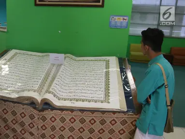 Pengunjung mengamati Alquran raksasa yang dipajang di perpustakaan Jakarta Islamic Centre, Jakarta Utara, Jumat (18/5). Alquran yang ditulis tangan tersebut sudah berusia 16 tahun. (Liputan6.com/Arya Manggala)