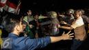 Aksi saling dorong antara massa dengan polisi saat unjuk rasa di depan Istana Negara, Kamis (12/1). Aksi sejenis dilakukan serentak di 19 titik kota berbeda di Indonesia. (Liputan6.com/Faizal Fanani)