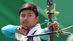 Pemanah putra Indonesia, Riau Ega Agatha berlaga melawan pemanah Korsel, Kim Woo-jin pada babak penyisihan Olimpiade 2016, di Rio de Janeiro, Senin (8/8). Ega mengalahkan pemanah yang juga merupakan nomor satu dunia itu dengan skor 6-2. (Jewel SAMAD/AFP)