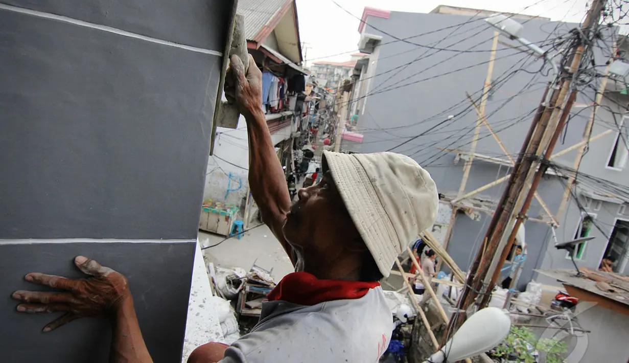 Seorang pekerja tampak merapikan bagian luar bagunan agar terlihat lebih halus dan indah, Kampung Deret Benhil, Jakarta Pusat, Rabu (14/05/2014) (Liputan6.com/Faizal Fanani).