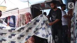 Aktivitas perdagangan tekstil di Pasar Cipadu, Tangerang, Senin (21/9/2020). Asosiasi Pertekstilan Indonesia (API) menyatakan industri Tekstil dan Produk Tekstil (TPT) sudah mulai beroperasi meski belum normal kembali akibat daya beli yang masih rendah di masa pandemi. (Liputan6.com/Angga Yuniar)