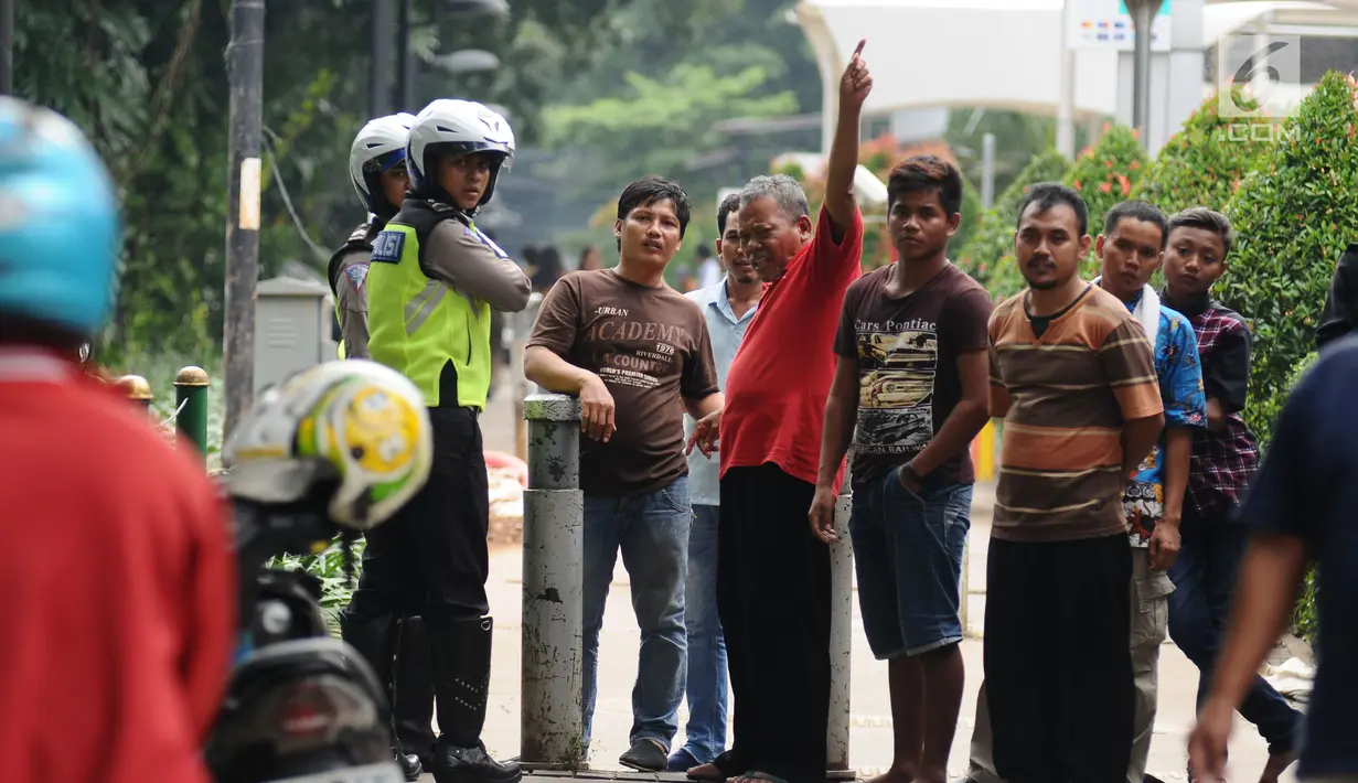 Petugas kepolisian melakukan sosialisasi dengan warga di trotoar Jalan Kebon Sirih, Jakarta, Senin (17/7). Hal ini tindak lanjut maraknya pelanggaran lalu lintas di kawasan pedestrian Jalan Kebon Sirih. (Liputan6.com/Helmi Fithriansyah)