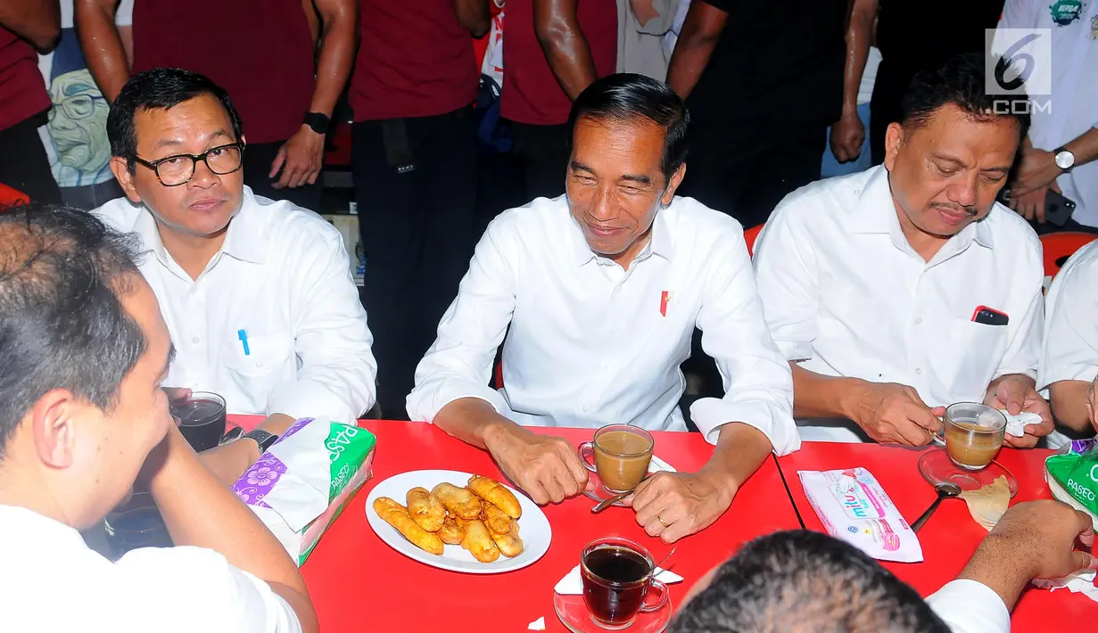 Capres nomor urut 01 Joko Widodo atau Jokowi, Politikus PDIP Pramono Anung dan Gubernur Sulut Olly Dondokambey saat ngopi di Jalan Roda, Manado, Minggu (31/3). Sambil menikmati kopi Jokowi bercerita pengalaman uniknya ketika berkunjung ke Sulut. (Liputan6.com/Angga Yuniar)