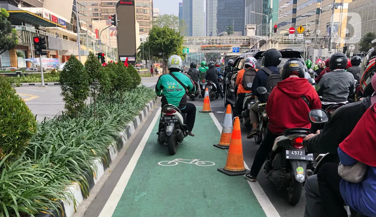 Pengendara motor melintasi lajur sepeda di Jalan MH Thamrin, Jakarta, Selasa (30/6/2020). Untuk menyikapi maraknya penggunaan sepeda sebagai sarana transportasi oleh masyarakat, Kementerian Perhubungan menyiapkan regulasi untuk pesepeda, khususnya aspek keselamatan. (Liputan6.com/Immanuel Antonius)