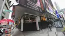 Seorang perempuan melewati sebuah toko yang dipasangi papan pelindung di Times Square di New York, Amerika Serikat pada 1 November 2020. Langkah itu dilakukan saat para peretail berupaya melindungi properti dari penjarahan atau kerusuhan lainnya dalam beberapa hari mendatang. (Xinhua/Wang Ying)