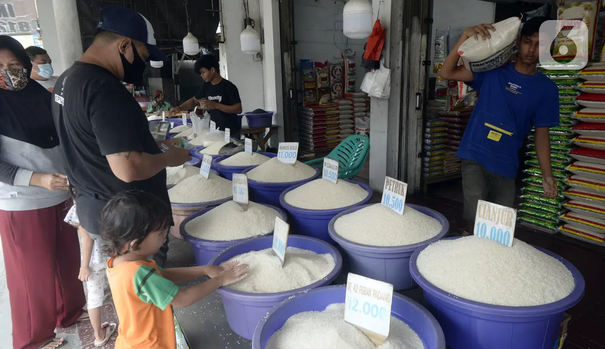 Pedagang beras melayani pembeli di pinggir Jalan Raya Pamulang, Tangerang Selatan, Banten, Jumat (11/12/2020). Jelang Natal dan Tahun Baru 2021, harga beras dipasaran masih normal tidak ada kenaikan. (merdeka.com/Dwi Narwoko)