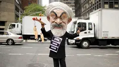 Max Saatchi, pemilik toko perhiasan melakukan aksi memakai topeng Presiden Iran Hassan Rouhani mengecam pelanggaran hak asasi manusia oleh pemerintah Rouhani di luar markas besar PBB, Manhattan, New York, AS (28/9/2015). (REUTERS/Darren Ornitz)