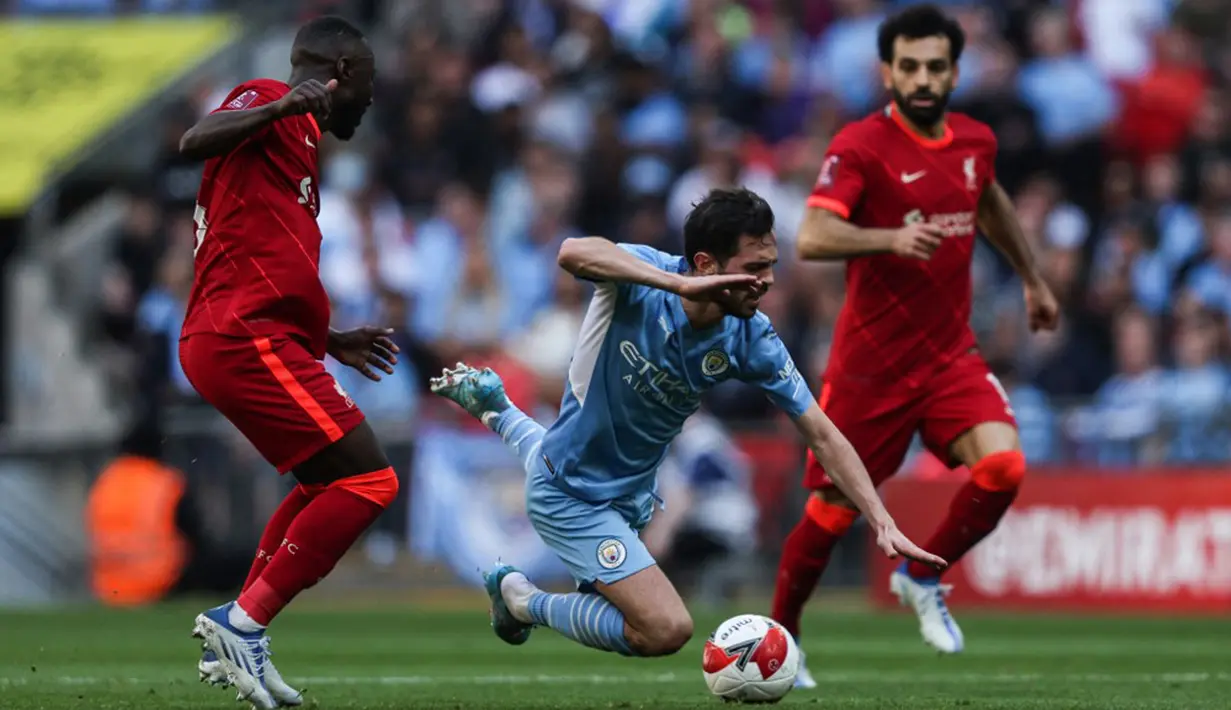 Pemain Liverpool Naby Keita (kiri) berebut bola dengan pemain Manchester City Bernardo Silva (tengah) pada pertandingan sepak bola semifinal Piala FA di Stadion Wembley, London, Inggris, 16 April 2022. Liverpool menang 3-2. (Adrian DENNIS/AFP)