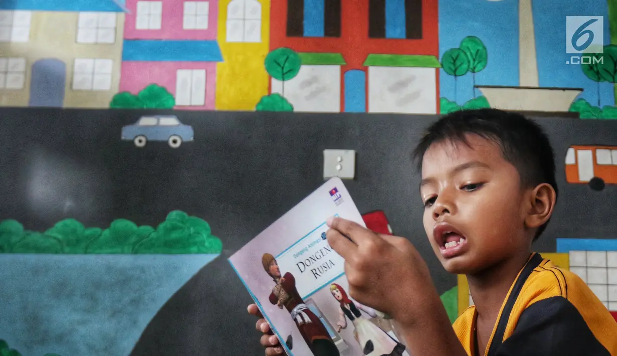 Seorang anak membaca buku di Ruang Perpustakaan RPTRA Kebon Sirih, Jakarta, Kamis (4/4). Dinas Perpustakaan dan Arsip DKI Jakarta bekerja sama dengan Jakarta Library menggelar Gerakan Baca Jakarta. (Liputan6.com/JohanTallo)