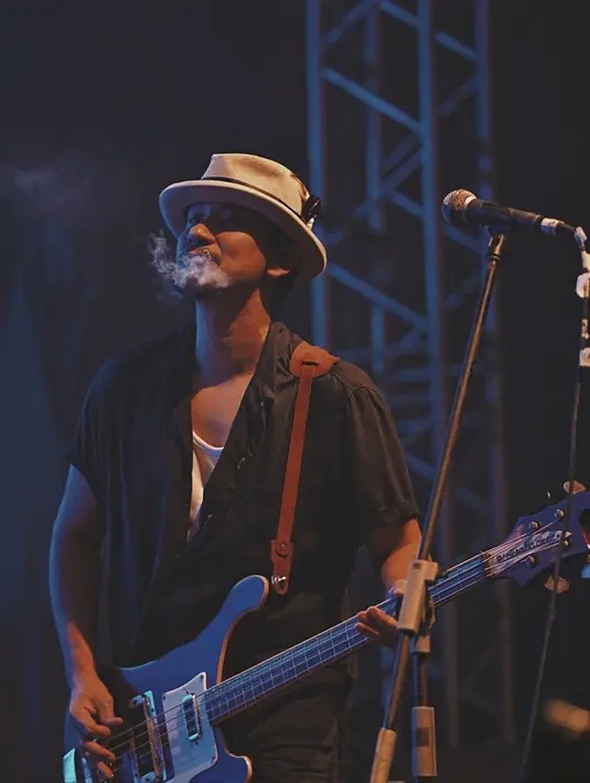 Dibawah sorot lampu temaram dan suara dentuman musik, Vincent tampil kece dengan kemeja gelap yang tak dikancing serta topi coklat. Aura semangat bassis The Cash ini semakin terpancar. (Liputan6.com/IG/@vincentrompies)