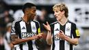 Pemain Newcastle, Anthony Gordon (kanan) berbincang dengan Joe Willock setelah laga leg kedua Carabao Cup 2024/2025 melawan Arsenal di St James Park, Newcastle, Inggris, Kamis (06/02/2025). (AFP/Paul Ellis)