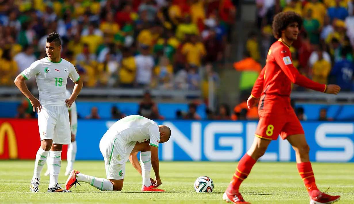 Marouane Fellaini (kanan) melewati dua pemain Aljazair sesaat setelah Dries Mertens mencetak gol kedua buat Belgia di penyisihan Piala Dunia Grup H di Stadion Mineirao, Belo Horizonte, Brasil, (17/6/2014). (REUTERS/Dominic Ebenbichler)