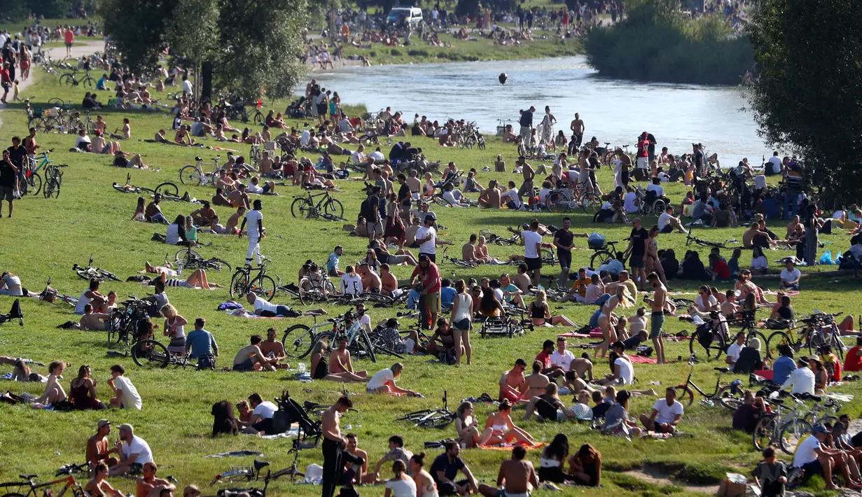 Ribuan orang menikmati cuaca musim panas di tepi sungai 'Isar' di Munich, Jerman (19/7/2020). Di tengah pandemi COVID-19, ribuan orang menikmati cuaca musim panas di dekat sungai tersebut untuk berjemur serta mendinginkan tubuh. (AP Photo/Matthias Schrader)
