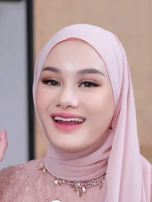 MUA Ikawati Fitria merias wajah Dinda dengan makeup bak Barbie. Mengaplikasikan lipstik pink tipis, berfokus pada riasan mata dengan eyehadow shimmernya. [Instagram/@ikawatifitria]