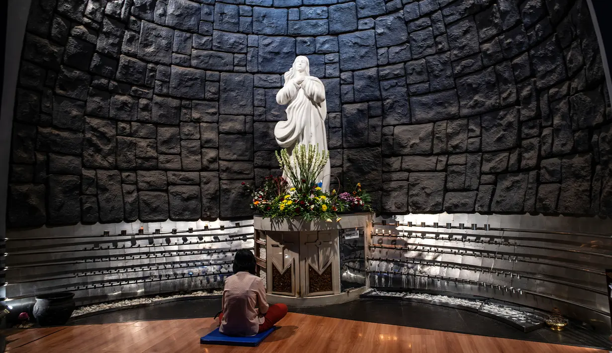 Seorang wanita berdoa untuk mengenang setahun tragedi bom gereja Surabaya di Gereja Katolik Santa Maria, Surabaya, Jawa Timur, Senin (13/5/2019). Pada peringatan tersebut digelar juga doa lintas agama yang dihadiri sejumlah pemuka agama. (Juni Kriswanto/AFP)