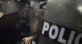Seorang demonstran bentrok dengan polisi anti huru-hara selama demonstrasi anti pemerintah di Lima, Peru pada 21 September 2025. (ERNESTO BENAVIDES/AFP)