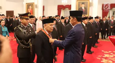 Presiden Joko Widodo atau Jokowi (kanan) menyematkan tanda kehormatan kepada tokoh nasional di Istana Negara, Jakarta, Kamis (15/8/2019). Sebanyak 29 orang mendapat gelar tanda kehormatan Bintang Mahaputra Utama dan Bintang Jasa Utama dalam rangka peringatan HUT ke-74 RI. (Liputan6.com/Angga Yuniar)