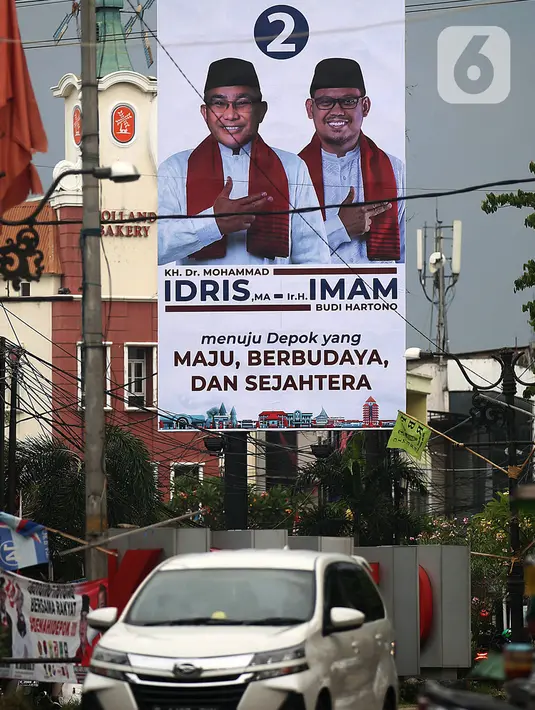 Kendaraan melintasi alat peraga kampanye (APK) yang terpasang di kawasan Depok, Jawa Barat dan Ciputat, Tangerang Selatan, Minggu (18/10/2020). KPU Kota Tangsel dan Depok membagikan sejumlah alat peraga kampanye kepada pasangan calon Pilkada 2020 serentak. (Liputan6.com/Johan Tallo)